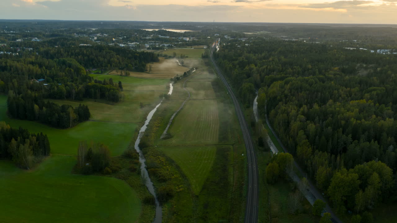 Hyperlapse drone shot of trains on the countryside, misty sunrise in Finland