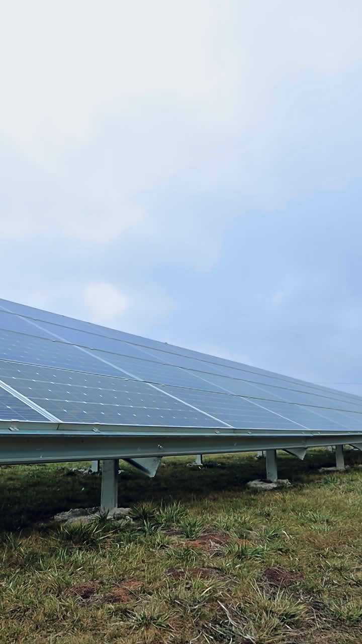 Eco solar battery on the grass under blue sky. Innovative technology in electricity. Photovoltaic solar panels for renewable energy. Vertical video