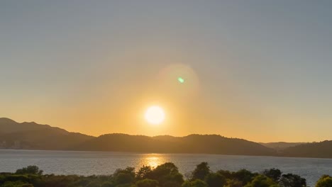 Aerial-view-over-Beautiful-Sunset-at-Outão,-Setúbal,-Portugal-drone-view-from-Troia-of-orange-sunset-with-sea-and-shore