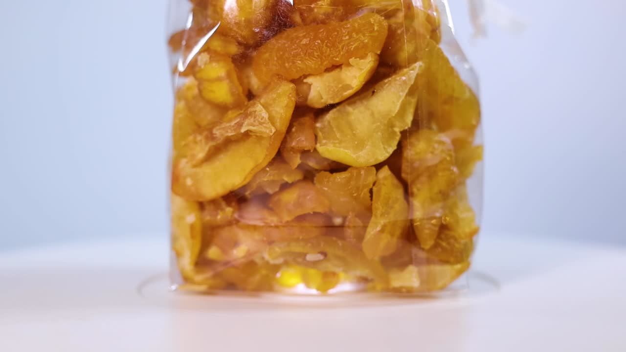 A clear container filled with freeze-dried quince pieces, highlighting their golden-yellow hue and natural texture. Perfect for snacking or adding to recipes.