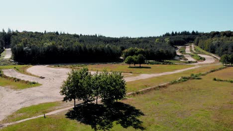 Woodland-downhill-freestyle-cycling-dirt-trail-route-descending-aerial-view-of-slope-terrain