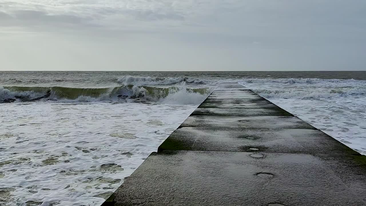 breaking waves of the North Sea on the beach of Borkum on a windy day