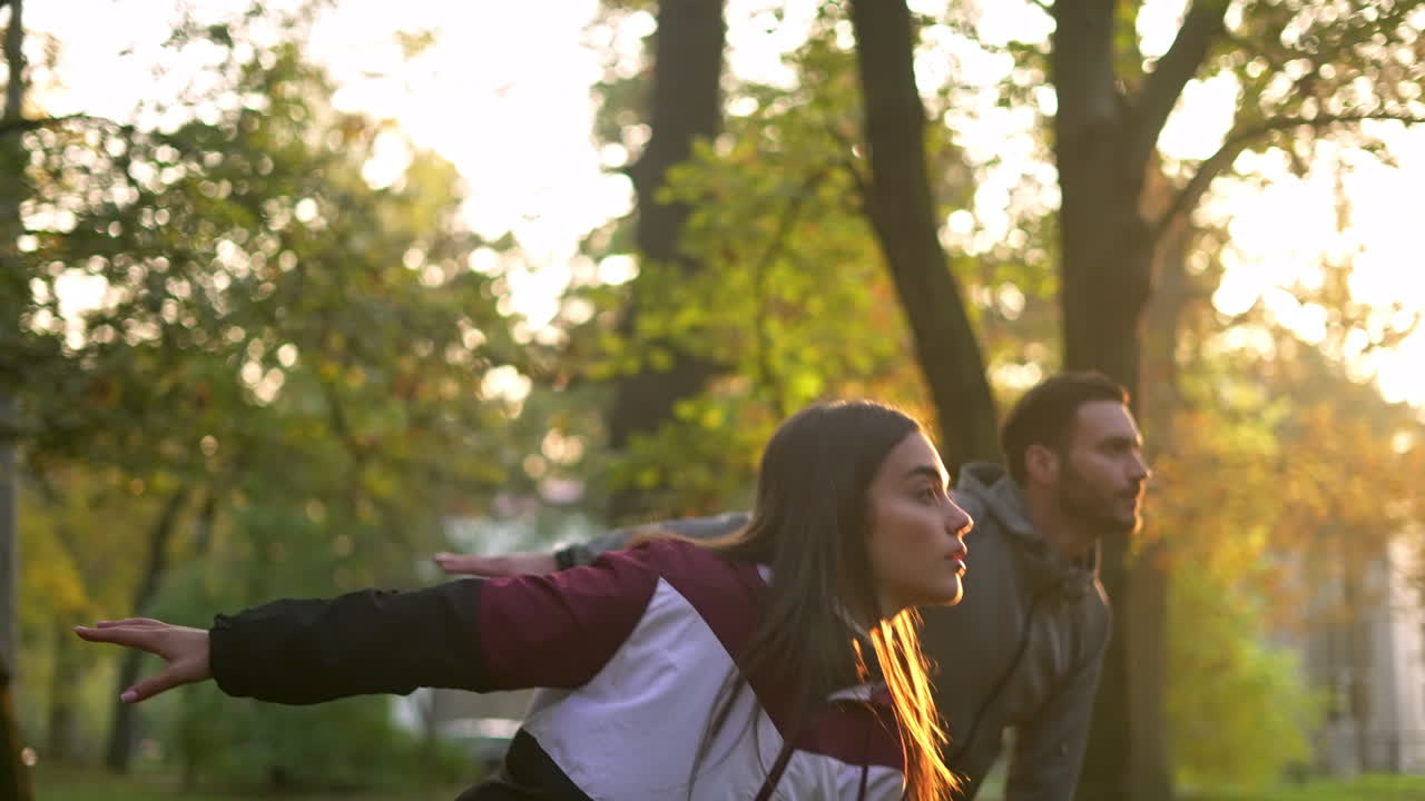Couple exercising with dumbbells in the park