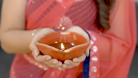 indian woman holding earthen lamp