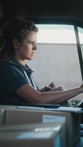 female delivery driver working in her van with packages