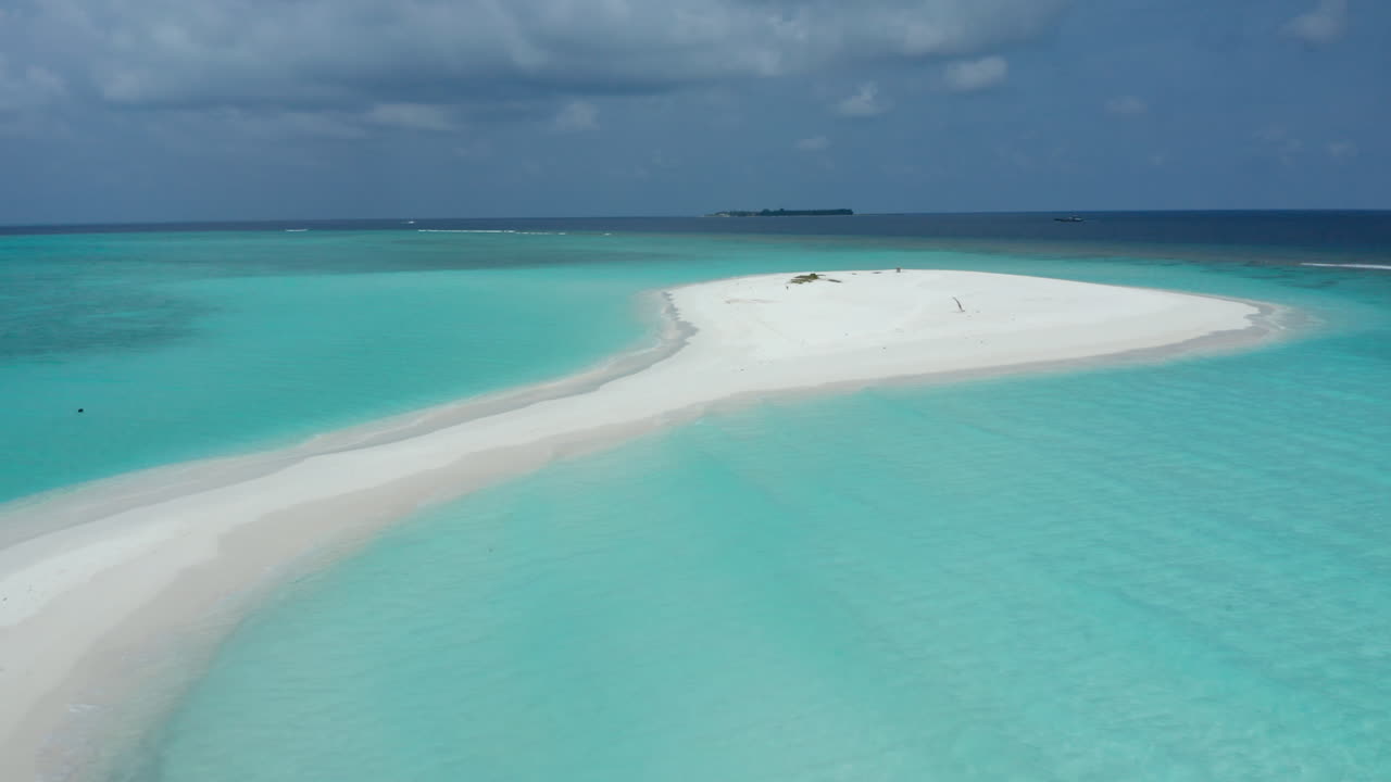 Bellissima spiaggia bianca con acqua cristallina e un'isola sullo sfondo, Maldive