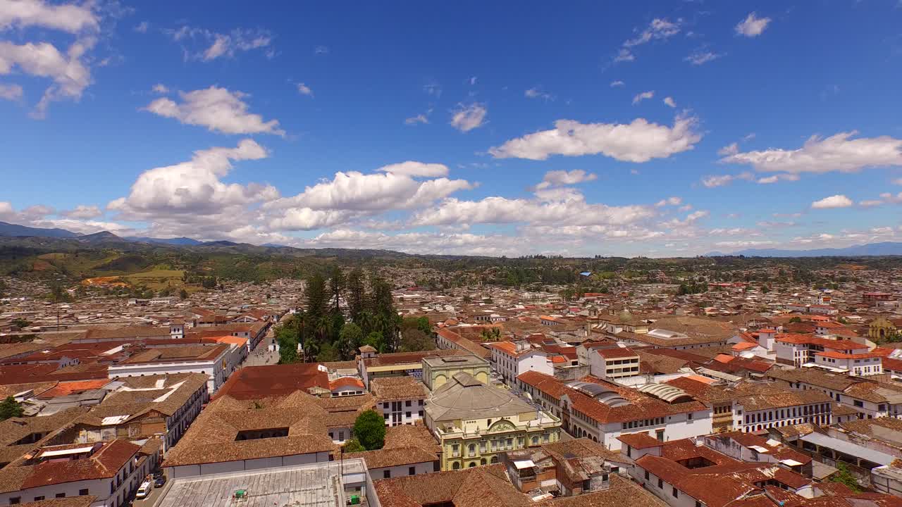 fotografía aérea que desciende desde la vista panorámica de popayan, colombia, con cielos azules y montañas como fondo