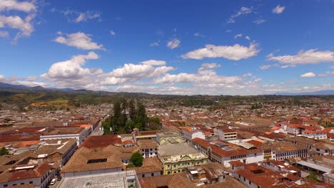 aerial shot descending from panoramic view of popayan, colombia, with blue skies and mountains as background