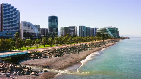 soleada playa del mar negro contra modernos rascacielos de apartamentos