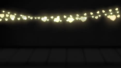 animation of yellow heart shaped glowing fairy lights hanging against copy space on black background