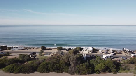 a beautiful aerial drone shot, drone flying backwards over the coast and beach houses with a view of the horizon and ocean, carlsbad state beach - california