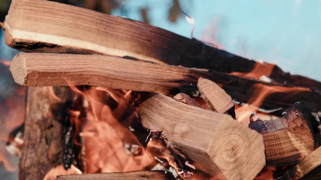 Meat skewers and traditional boerewors on grid turned during open fire barbecue