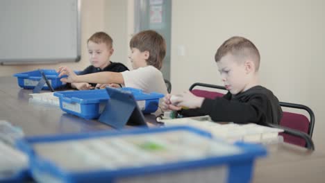 children engage in stem learning activities, assembling robotics kits with focus and teamwork in a classroom setting