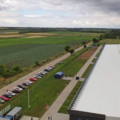 white commercial building among nature. modern industrial plant with cars nearby in a summertime. exterior of innovative center. aerial view.