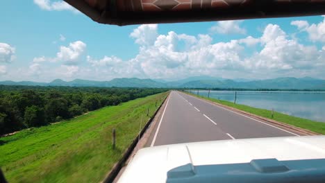 long and green road into the udawalawe national park in sri lanka.