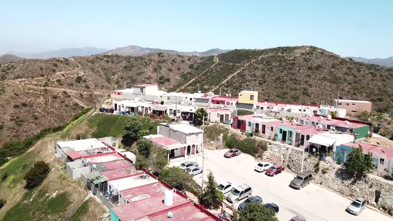 Drone footage of Haciendo Las Delicias, Baja, Mexico in the daytime. Starts up close then cinematically reveals more hillside homes.