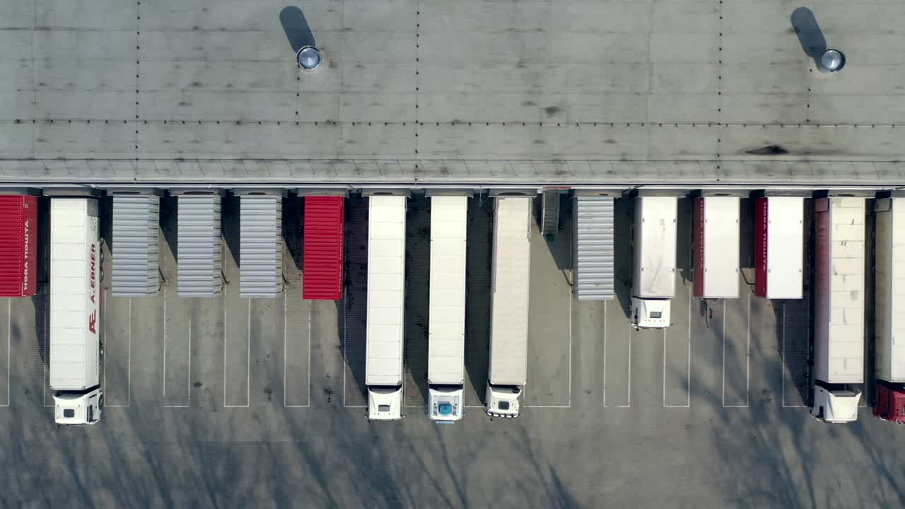 Aerial shot of truck drives up at warehouse for loading or unloading. Logistics, distribution center.