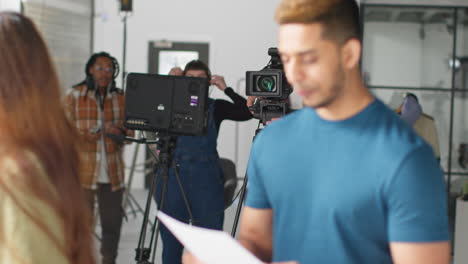 actores ensayando en el set rodando una película o un video en el estudio con una directora, un camarógrafo, un grabador de sonido y un asistente