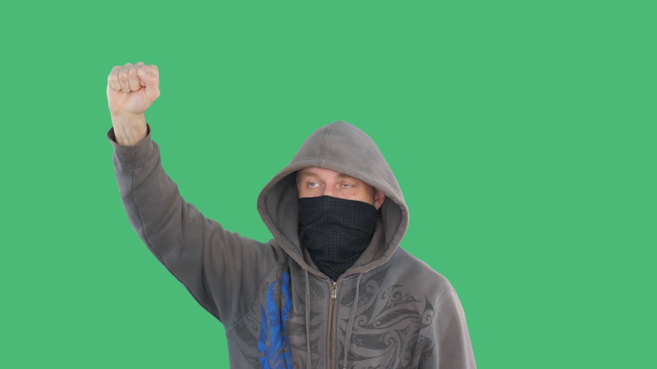 """녹색 바탕에 반란을 일으키는 주먹을 휘두르는 프로테스탄트 사회 집회, 반다나와 후드를 입은 분노한 남자가 정치적 반란에서 주먹을 들고 손을 들어 올린 것, 인민 반란 개념"""