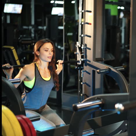 young beautiful woman in a gym doing sit-ups with a bar in front of a mirror. women's athletics square video