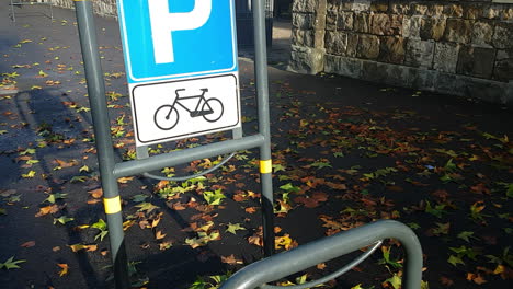 Tilt shot of a bike stand with a lot of leaves laying at the ground. Florence Rifredi metropolitan area