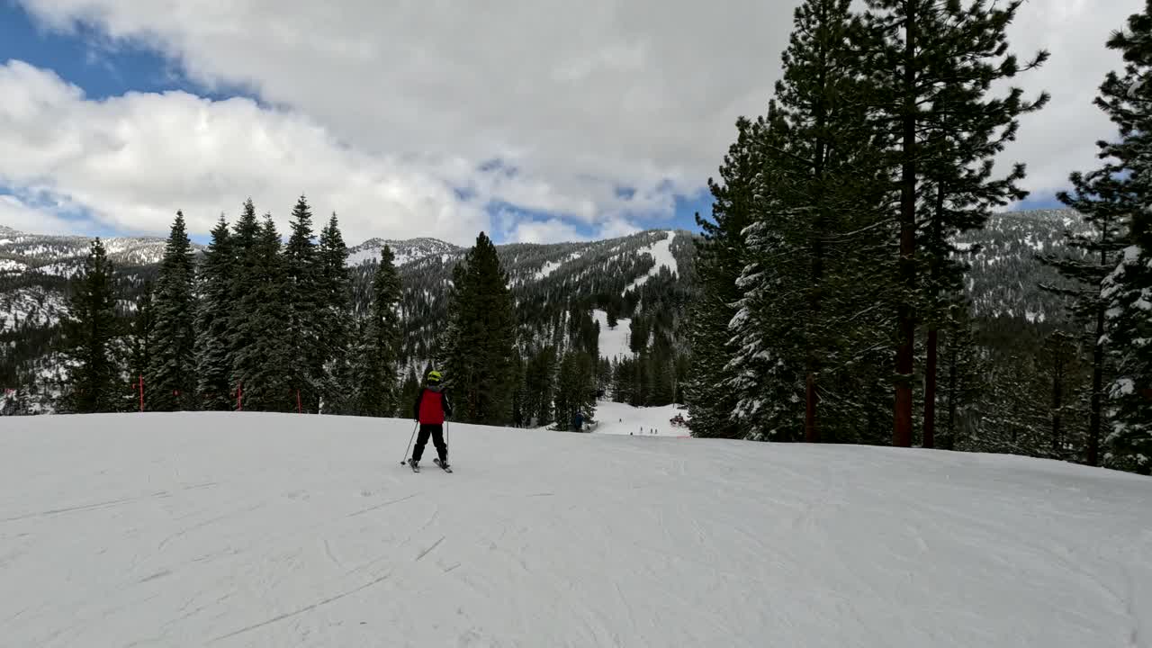 Ragazzo che scia giù da una montagna innevata