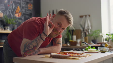 chef smelling pizza and showing ok gesture