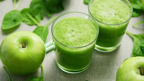 cups with green smoothie on table