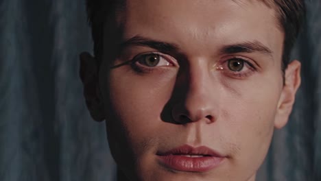 close-up video still of a person's face in shadow, side-lit for dramatic effect, with a focus