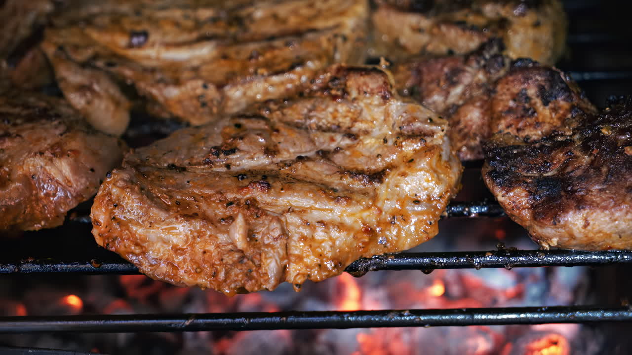 Roasting juicy meat steak with spices and herbs in burning charcoals fire on barbeque grid. Flames and smoke. Close up