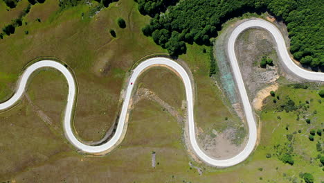 Above-Twisted-Serpentine-Asphalted-Road-Carretera-Australe-Pass-Cerro-Castillo-Chile-Curves-Green-Red-Car-Driving