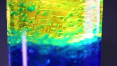 vibrant liquid layers interacting in a glass container