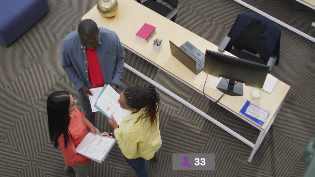 Team of three reviewing docs for marketing, scanning and causing notif badges organizing above desk