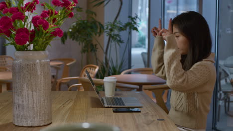 young pretty asian chinese girl having online call, gestures with hands