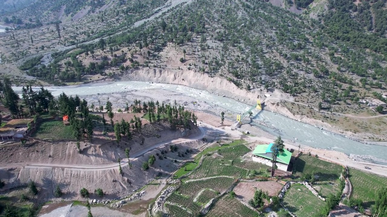 Kalam'daki Utror Vadisi'nin kıvrımlı nehri, yemyeşil terasları ve engebeli dağlık arazisi. Seyahat belgeselleri ve sürdürülebilirlik temaları için mükemmel.