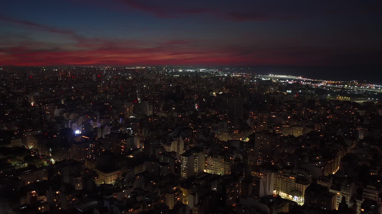 Aerial night view over Buenos Aires with glowing city lights and sunset sky. Urban landscape