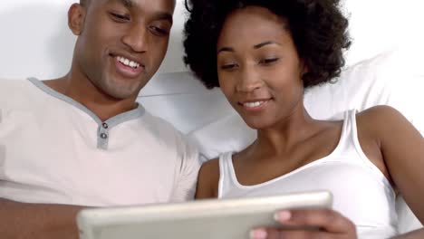 smiling couple using tablet together