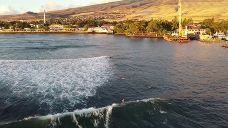 surfers riding waves at sunset in one of hawaii´s surf beaches