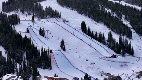 half pipe big air jump ski snowboard gondola ski lift aerial drone cinematic copper mountain colorado winter december christmas ski runs trails landscape vail cloudy rocky mountains circle right