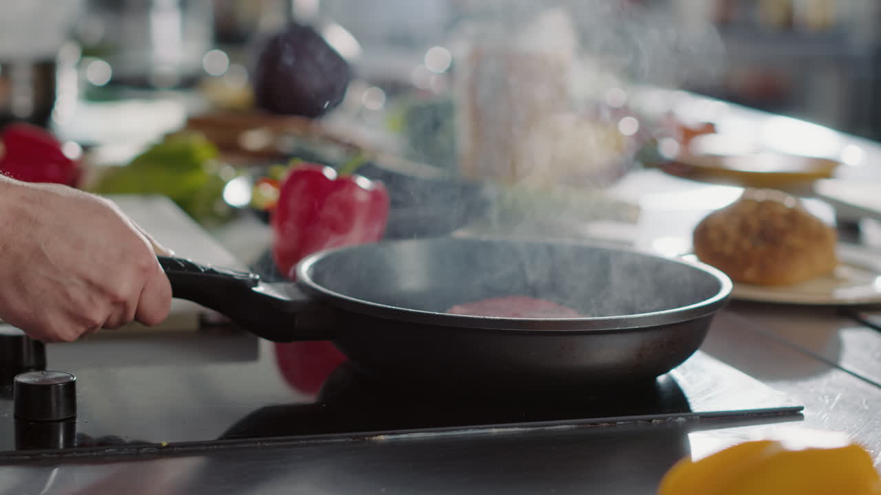 Male chef cooking beef steak in steam with sunflower oil