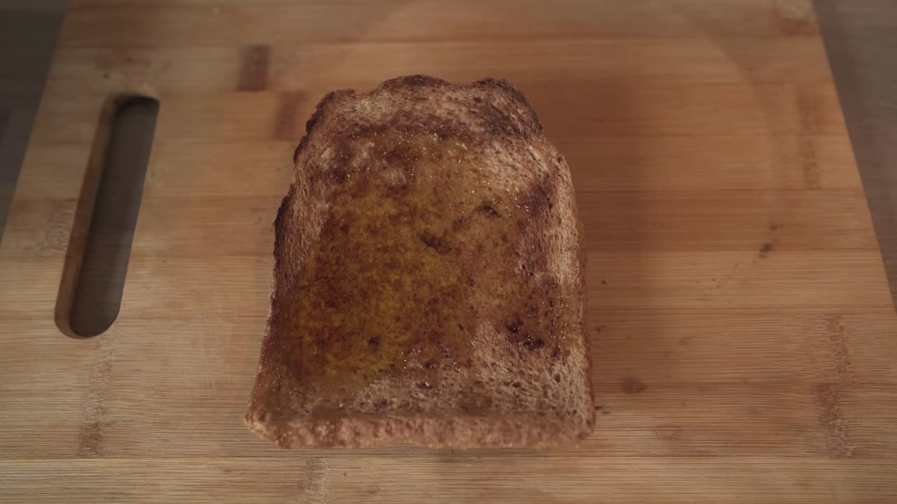 Olive Oil Drizzled Over Toasted Bread In Wooden Board
