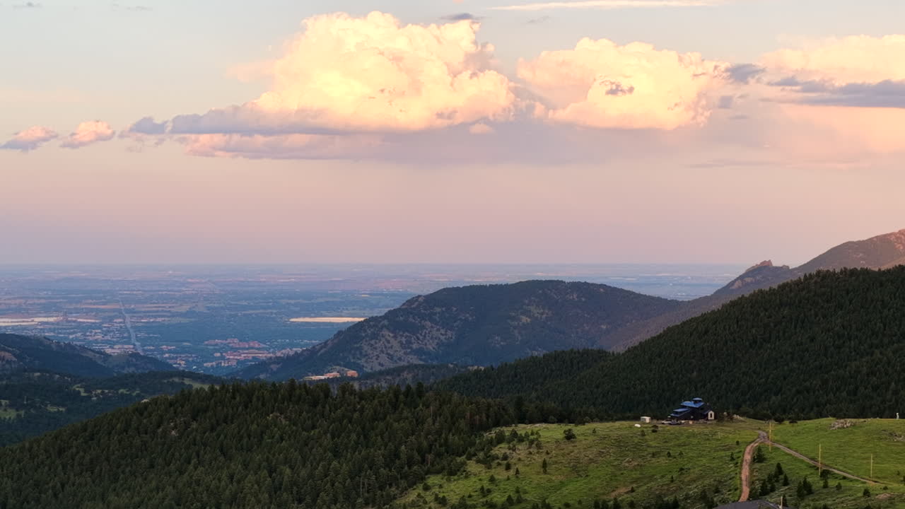 Drone footage of a summer sunset over the mountains near Boulder, Colorado. Aerial view of scenic wilderness, ridges, and forested landscapes.