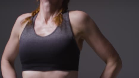 studio portret van volwassen vrouw in fitnesskleding die rust en herstelt na oefening 1