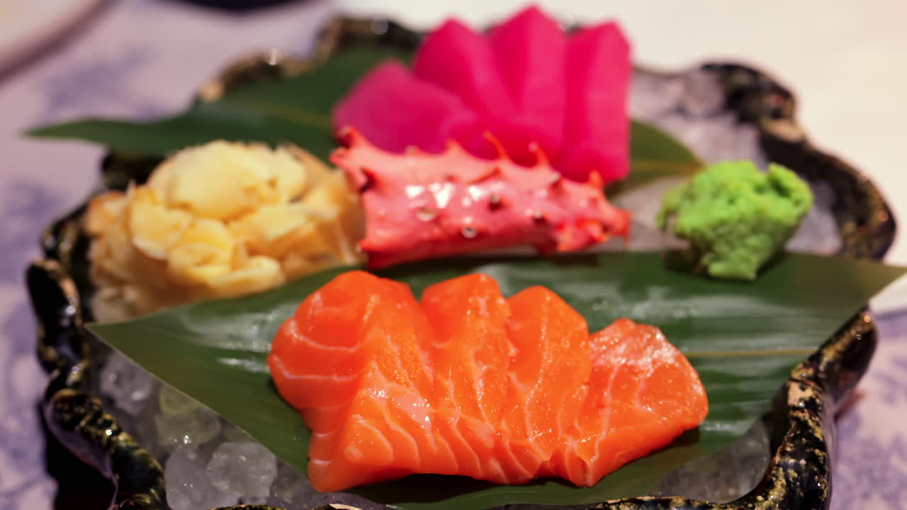 Close up of tuna and salmon sashimi on banana leaves on ice