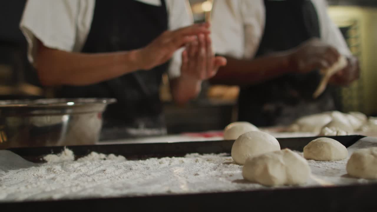 Animation of hands of diverse male and female bakers preparing rolls
