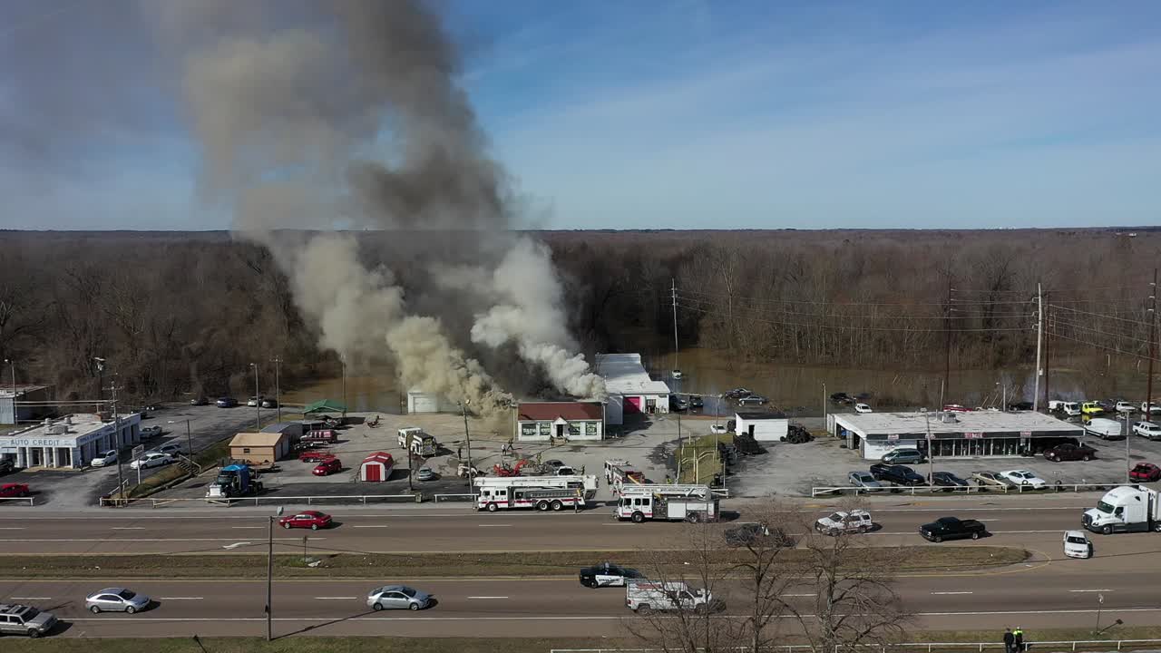 Drone view closing in to focus on the active fire with multiple agencies in attendance including local fire and police