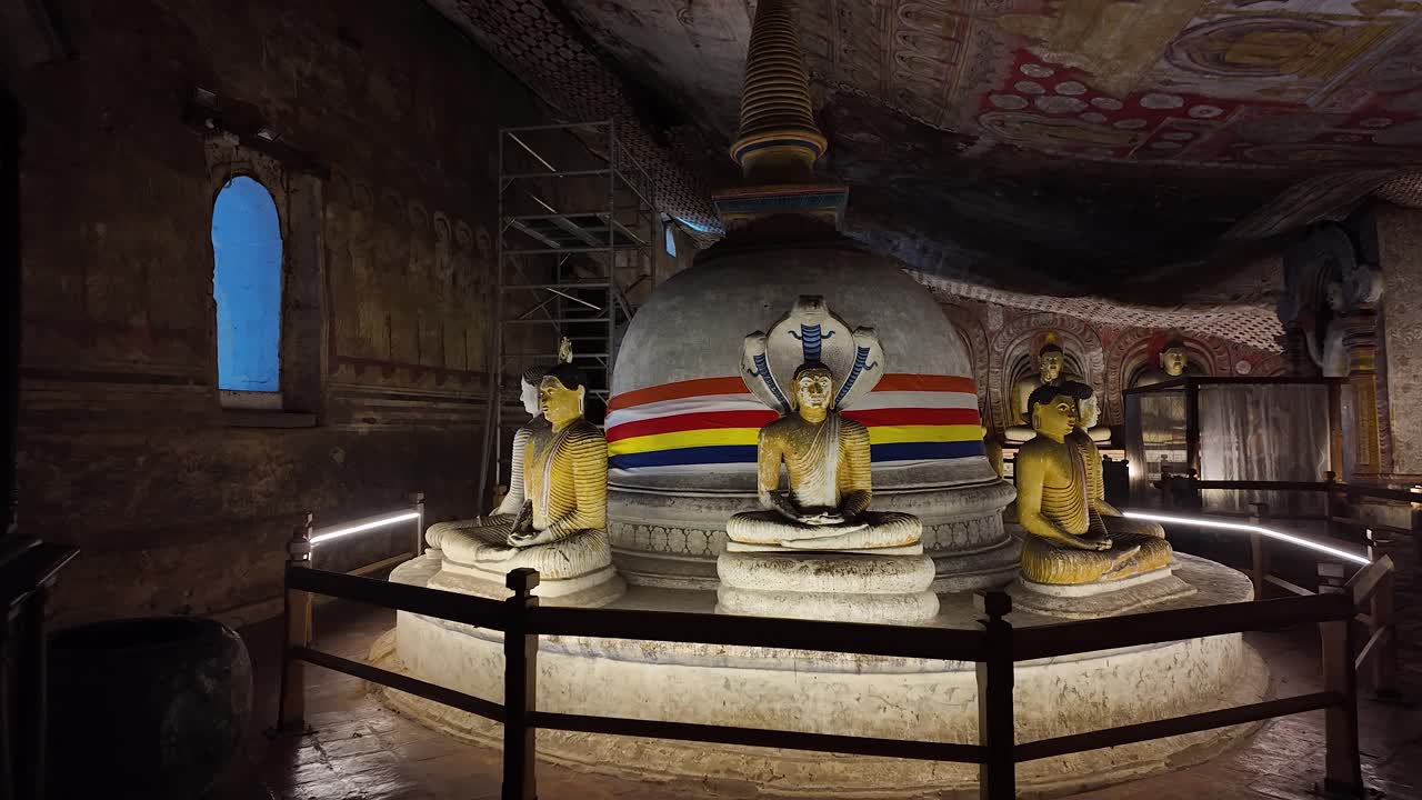 Seated Buddhas around a stupa inside the historic Dambulla Cave Temple in Sri Lanka, showcasing intricate artistry and spiritual ambiance. Push Forward Shot