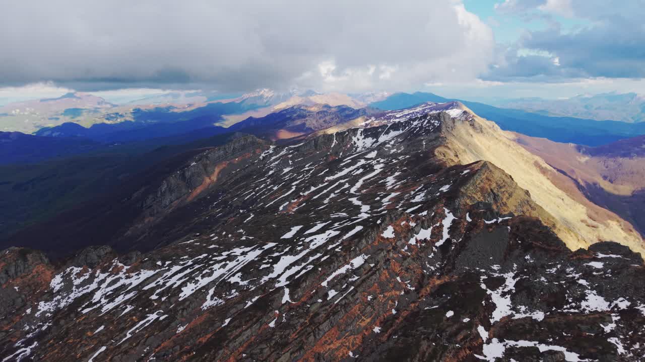 Majestic aerial shot of Dolomites Mountains, showcasing rugged terrain and snow-capped peaks