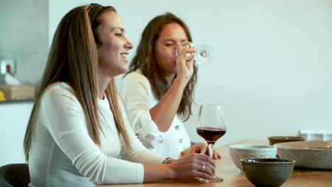 Laughing-young-woman-sitting-at-table-with-friends