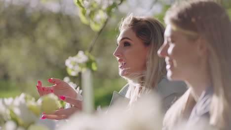 friendly-dinner-party-in-blooming-garden-in-spring-or-summer-young-pretty-women-are-chatting